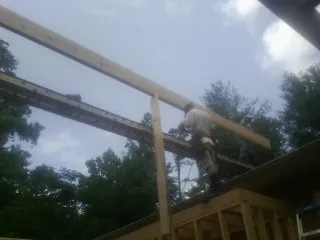 Carpenter setting a ridge beam over a new addition frame — Ice Dam Removal by Roofing Brothers in Schenley