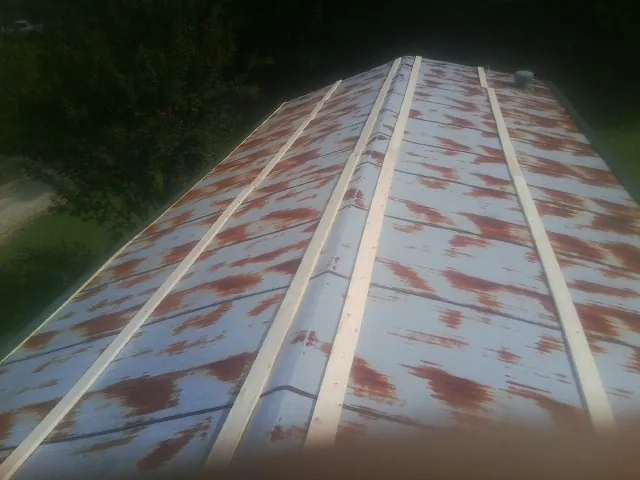 Rusted metal roof panels with new wood purlins before replacement — Storm Damage Roof Repair in Schenley by Roofing Brothers
