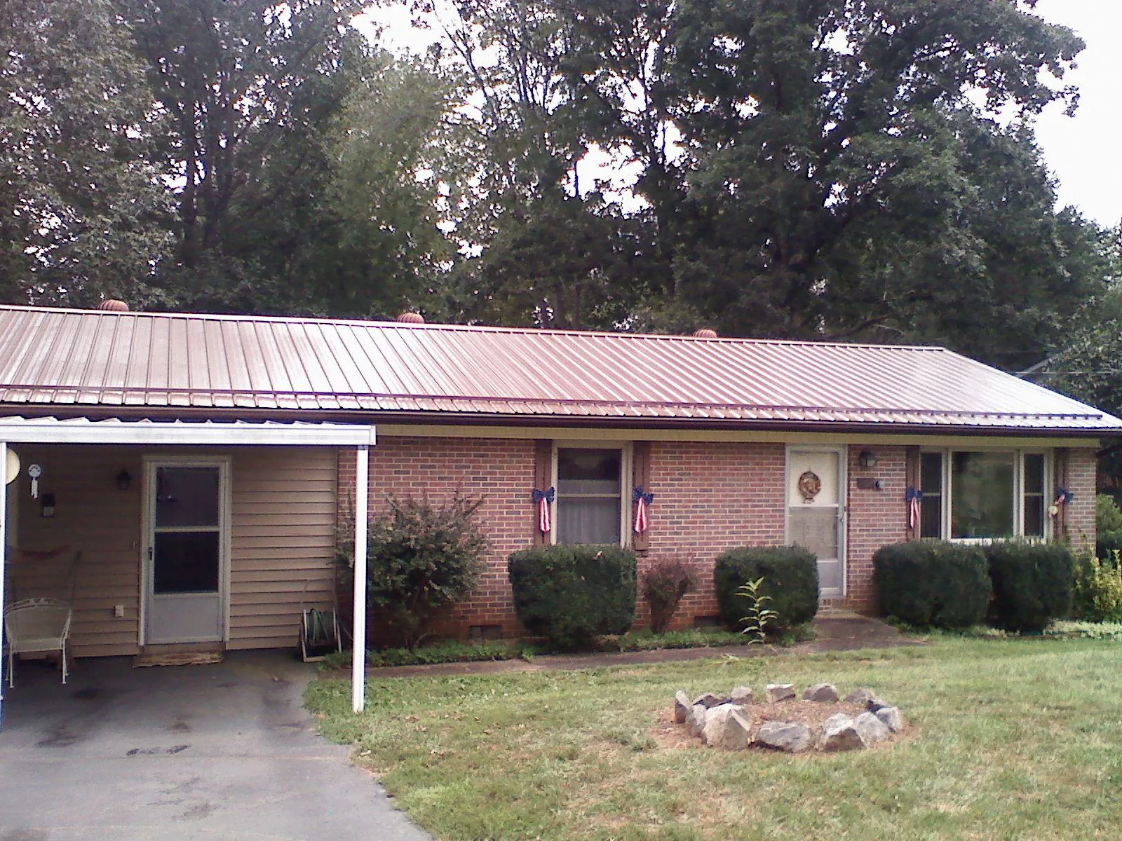 Bronze metal roof and carport on a brick ranch home — Roof Repair work by our crew in Schenley