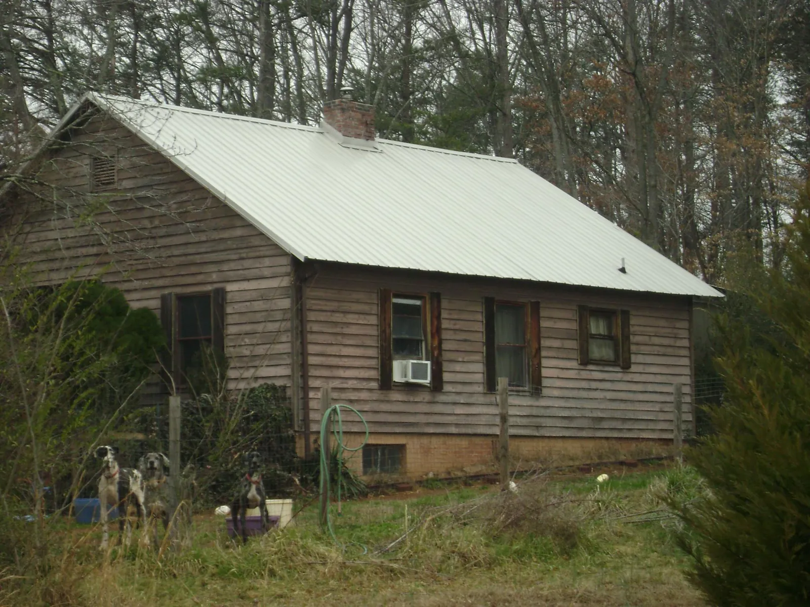 White metal roof on an old wood sided farmhouse, from a Metal Roof Installation job in Schenley